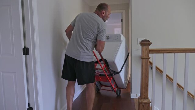individual pauses post heavy household work, lightskinned laborer unwinds following strenuous lifting task, fairskinned worker relaxes after intense effort carrying and moving items
