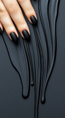 Close-up of a hand with matte black nail polish, resting on a dark, textured surface with flowing black liquid.