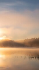 Fototapeta premium Golden sunrise over a tranquil lake with misty forest backdrop.