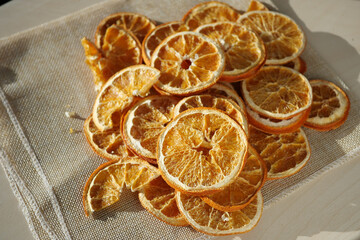 Dried orange slices on a cloth surface in sunny light