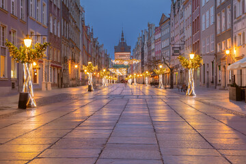 Decorated Dluga Street with festive lights and historical buildings in Gdansk Poland during winter evening