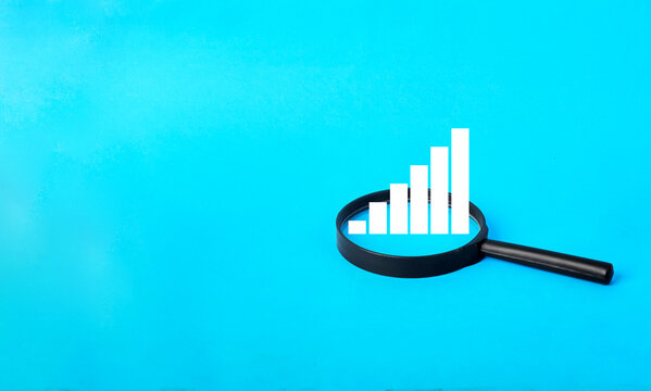 A magnifying glass highlighting ascending bar growth to represent performance evaluation, business progress and strategic development insight.
