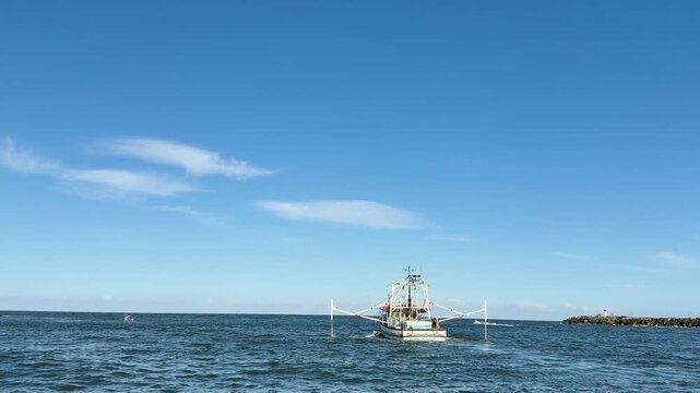 Commercial Fishing Trawler Entering River Channel at Sunset