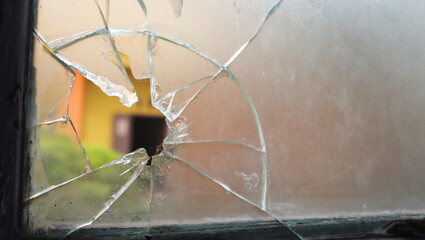 A broken window glass creates a gaping hole.