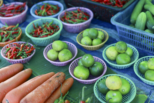 Vibrant assortment of fresh vegetable like lime, chili, and carrot at local outdoor market stall. colorful and healthy produce for sale creates an appetizing, authentic scene - Powered by Adobe