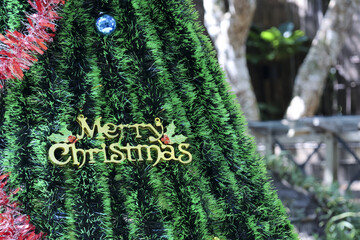 Merry Christmas greeting sign, festive holiday decoration on green tree. joyful and close up view capturing happy spirit for seasonal winter celebration