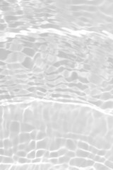 White water with ripples on the surface. Defocus blurred transparent blue colored clear calm water surface texture with splashes and bubbles. Water waves with shining pattern texture background.
