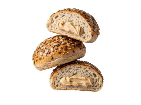 Three halves of a whole grain bread roll topped with seeds, filled with peanut butter, isolated on transparent background