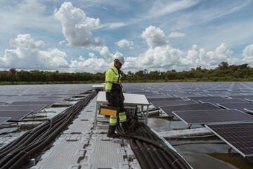 Professional workers clean and inspect solar panels on a floating buoy. Power plant with...