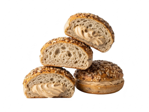 Stack of four multigrain bread rolls, two cut in half revealing creamy filling, isolated on transparent background