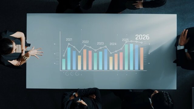 Aerial view of a business meeting showcasing colleagues discussing financial projections on a table featuring colorful graphs and data analytics for strategic decision-making. Raster - Powered by Adobe