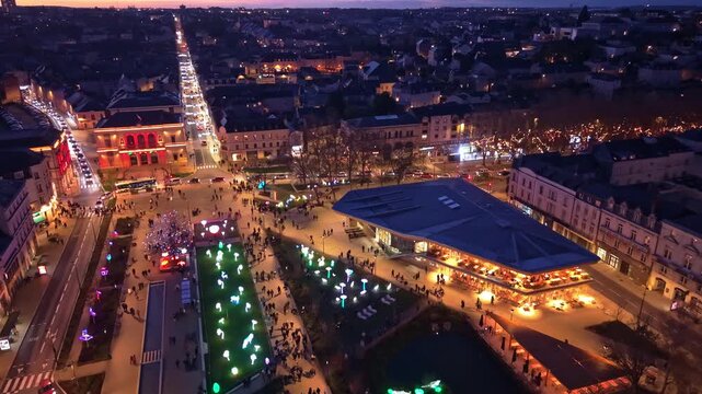 Aerial evening view of Place du 11-Novembre in Laval, Mayenne, France, during the Lumi&egrave;res de Laval Christmas event, showing the illuminated square, Bains Douches building and light installation