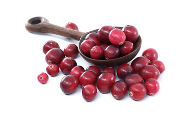 Fresh Red Cranberries in a Wooden Scoop Spilled Across a White Background for Healthy Snack Concept