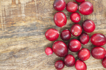 Fresh Red Cranberries Spilled Across Rustic Wooden Surface for Market, Kitchen, and Holiday