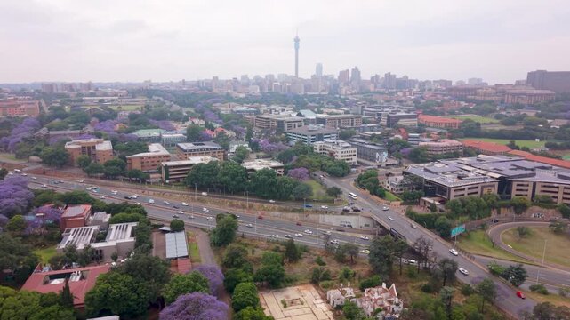 Aerial of morning traffic on Johannesburg N1 highway with Joburg city and Hillbrow in the distance on cloudy day.