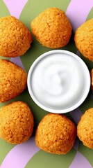Overhead shot of fried food arranged around a bowl of white dip on a colorful background.