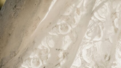Close-up of delicate white lace fabric with floral patterns.