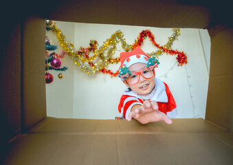 Child in Santa Outfit Sharing Festive Joy Open Present Gift Box, Happy Kid Opening Giftbox in Xmas Tree Home Interior