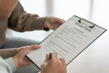 Divorce. Husband review and show sign Divorce form. Couples desperate and disappointed after marriage. wife sad, upset and frustrated after quarrels conflict. distrust, love problems