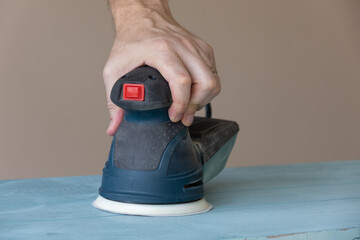 Woodworker Removing Paint With Power Sander