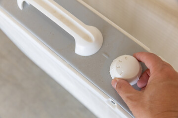 Hand turning dial on box fan