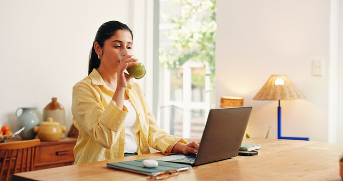 Laptop, reading and smoothie with business woman in home office for detox drink or research. Computer, green juice beverage and remote work with Indian freelancer at desk in apartment for startup
