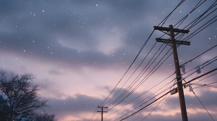 Serene twilight sky with falling snow silhouetted telephone poles and complex power line networks