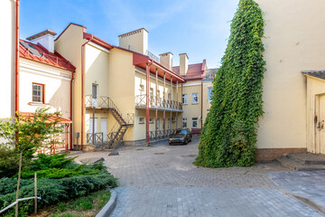 Sunny Courtyard with Residential Buildings, Ivy Wall and Parking Area