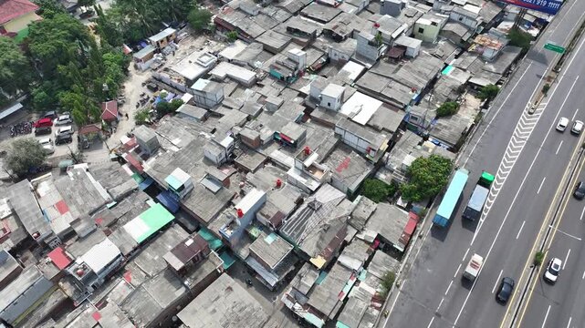 Aerial drone shot flying over densely packed houses homes, buildings with sohna expressway passing through the middle showing cityscape of jakarta
