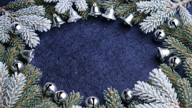 Winter spruce branch wreath composition with jingle bells creating central copy space holiday greeting card background