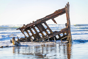 Naklejka premium The Rusted Remains of Peter Iredale Shipwreck at Sunset