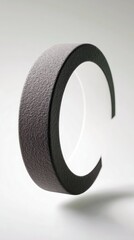 A close-up shot of a textured letter C floating in front of a white background, lit by studio lighting.