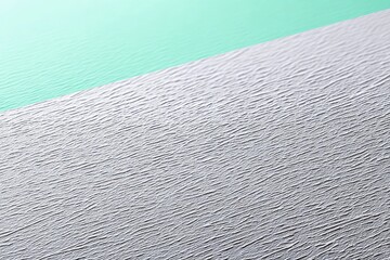 Close-up of textured paper with a color gradient. The image features a diagonal division between a textured white surface and a smooth green background.