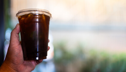 A man hand holding refreshing iced americano coffee