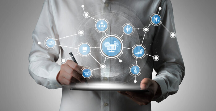 A business professional engages with a digital tablet displaying floating icons that symbolize technology, data connectivity, and innovative solutions in a contemporary workspace. Tessel - Powered by Adobe