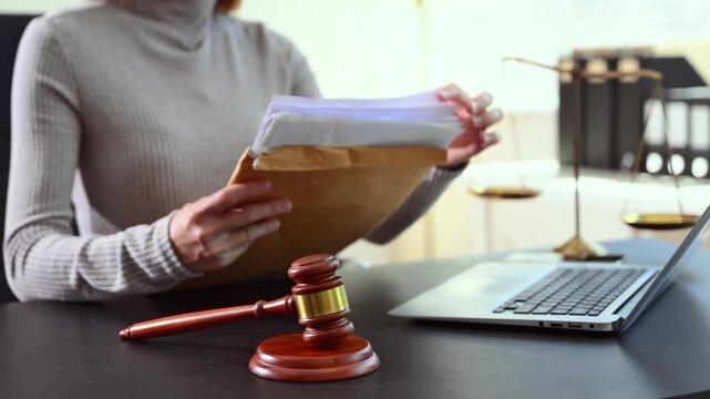 justice and law concept. Female judge in a courtroom the gavel, working with smart phone and laptop and digital tablet computer on white table