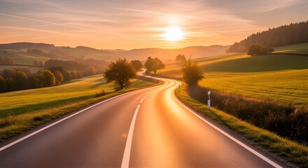 Fototapeta premium Golden hour reflections on a winding road surface through green hills under a sunset sky, a picturesque view of a serene journey