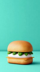 A stylized burger with basil leaves and cheese on a turquoise background. The image is a studio shot with soft lighting.