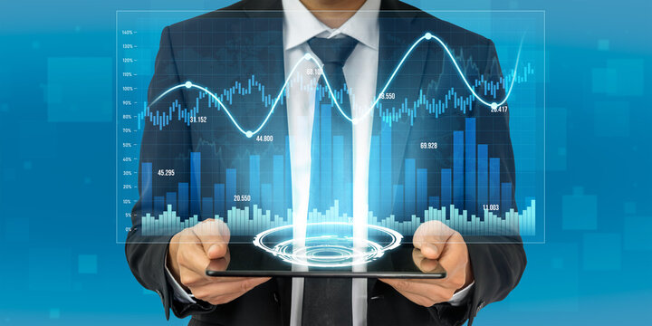 A businessman holds a digital tablet showcasing dynamic stock market trends and financial graphs, representing investment opportunities in a modern office setting. Scalp