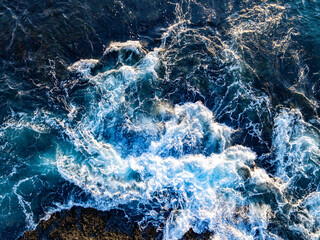 Scenic ocean landscape top view. Coastline from above. Sea water texture. Blue ocean water. Aerial view of ocean waves. Dramatic waves on reef. Coastal rocks and ocean surf. Tropical coastline.