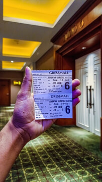 Hand holding two cinema tickets for the movie gressmall jembatan shiratal mustad, date tue 14 oct at 21:00. Entertainment and leisure, indonesia, 3 december 2025