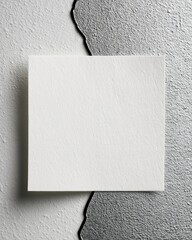 A blank square card is centered against a textured background with a split design, creating a minimalist and abstract composition.