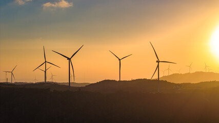 Aerial view of windmill turbines park generating green energy electric.Solar panels park and wind turbines at sunset.Green energy reduce carbon emissions and makes earth cleaner, Quang Tri, Vietnam