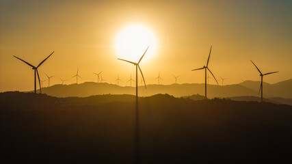 Aerial view of windmill turbines park generating green energy electric.Solar panels park and wind turbines at sunset.Green energy reduce carbon emissions and makes earth cleaner, Quang Tri, Vietnam