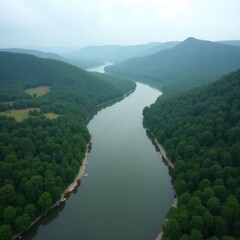 Aerial view of a wide river winding through lush green forested mountains