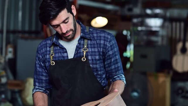 Luthier making top of guitar using traditional tools in workroom with manual tools, arts and craft concept.