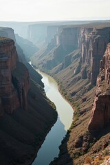 Majestic canyon with river winding through steep cliffs under sunlight