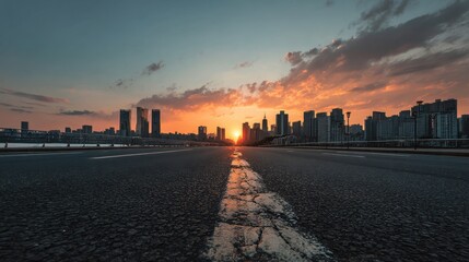 Obraz premium The city street is empty and quiet, with a large building in the background and a beautiful sunset in the sky. The sun is setting, casting a warm glow over the city. The street is lined with buildings