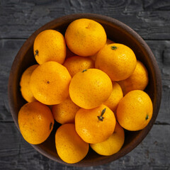 Fresh Juicy Oranges in Rustic Bowl on Dark Wooden Table - Natural Citrus Fruits