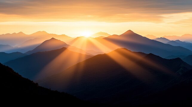 A scenic landscape photograph of mountains at sunrise, with golden sunbeams radiating through the sky.